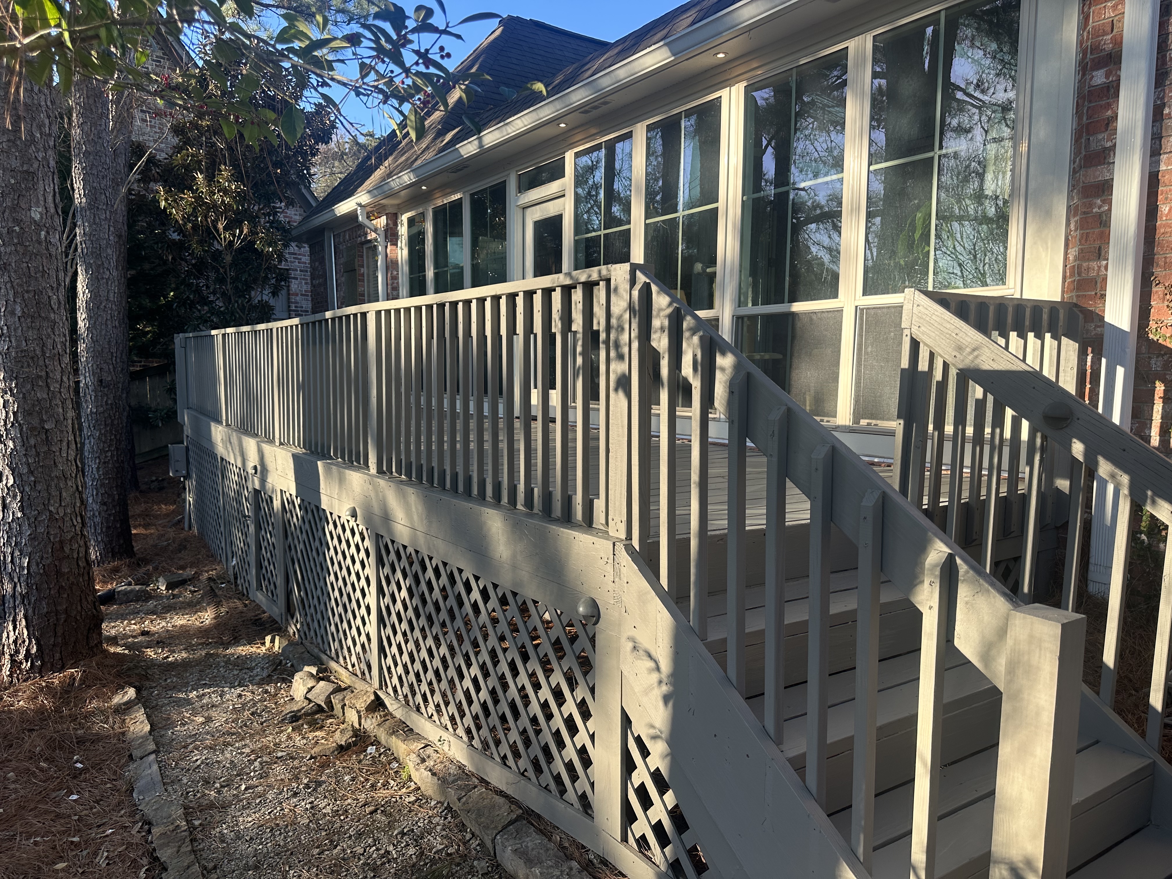 Finished gray painted deck with railings and lattice