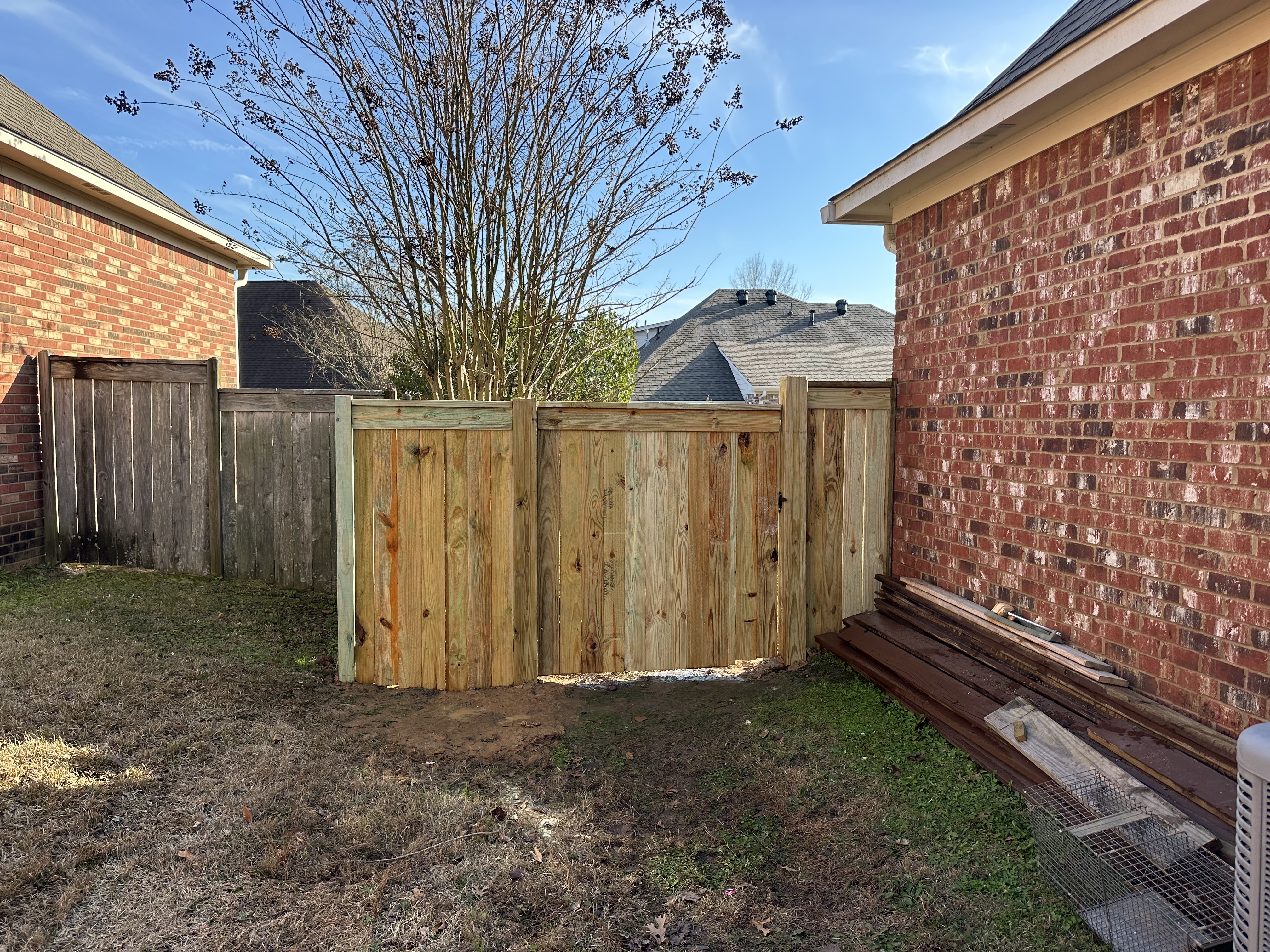 Fresh pressure-treated privacy fence installed